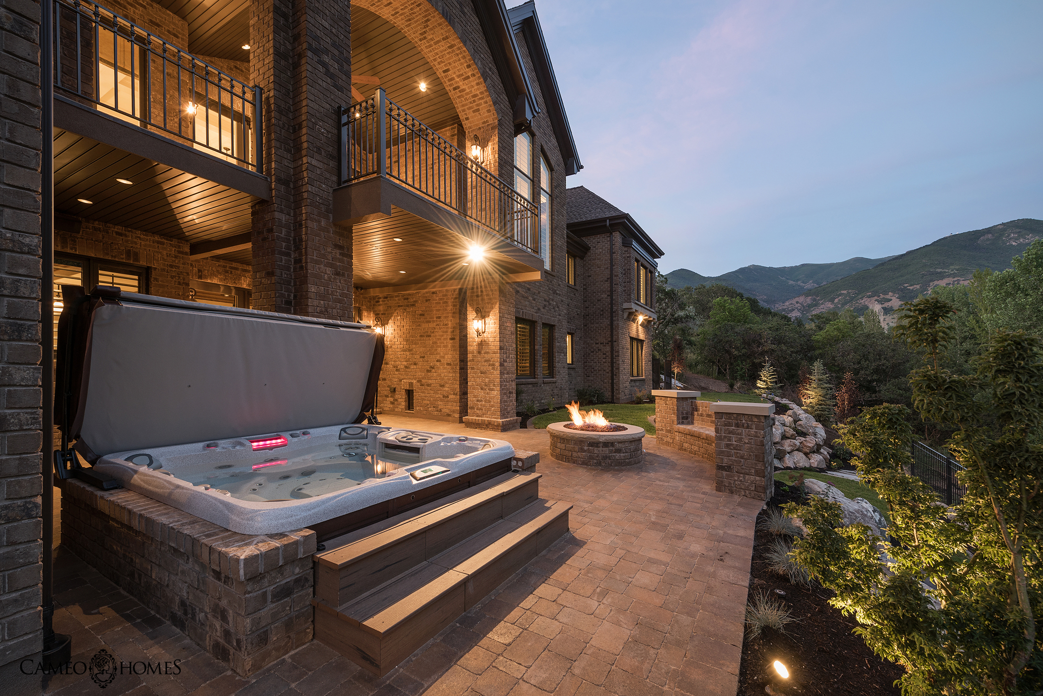 Hot tub with cover lifted outside of a beautiful house along the countryside.