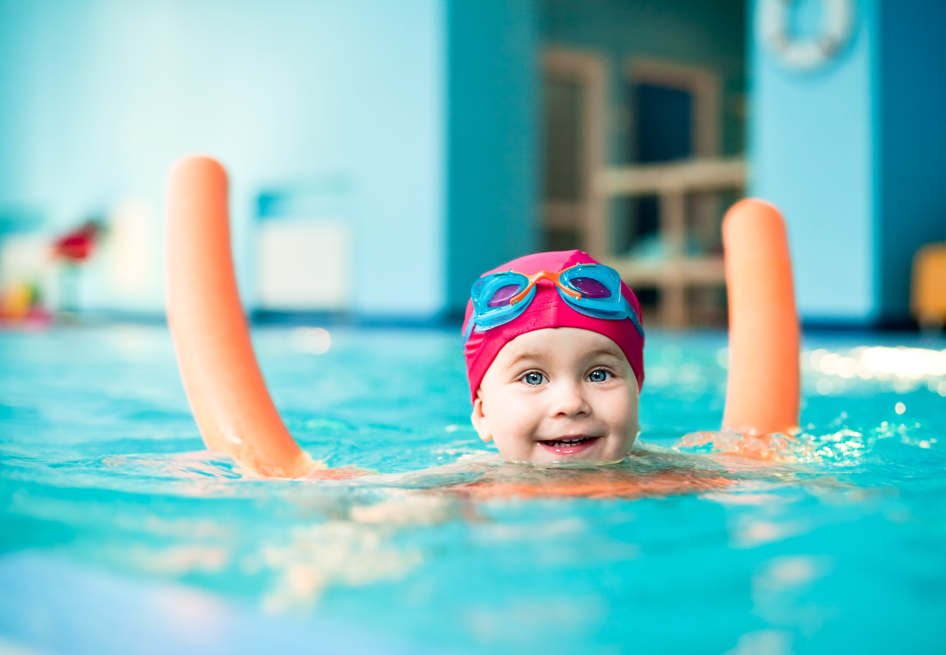 Child having fun playing games in a swimming pool.