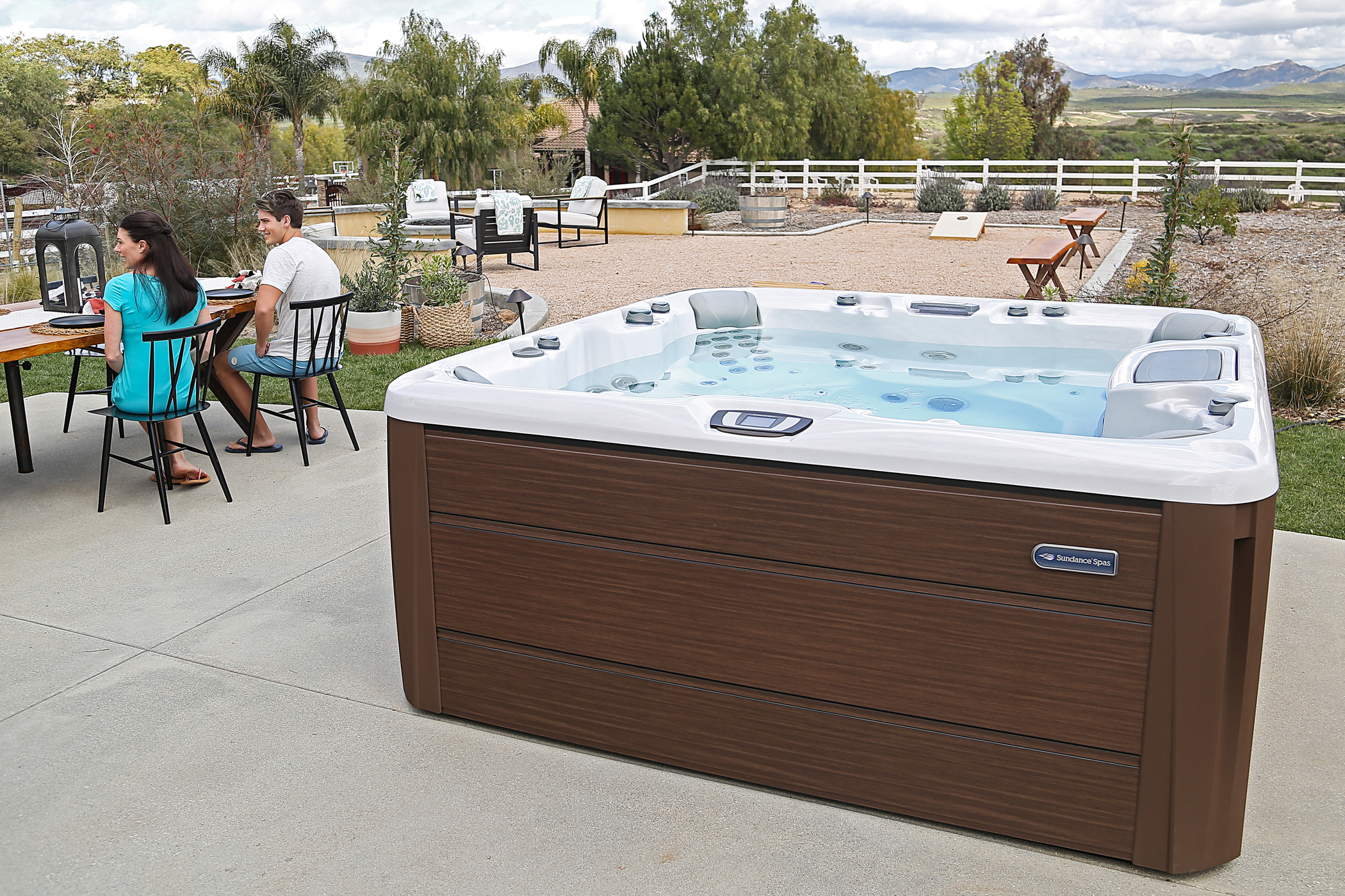 Sundance Spas hot tub in a Texas backyard with family nearby.