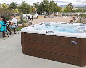 Sundance Spas hot tub in a Texas backyard with family nearby.