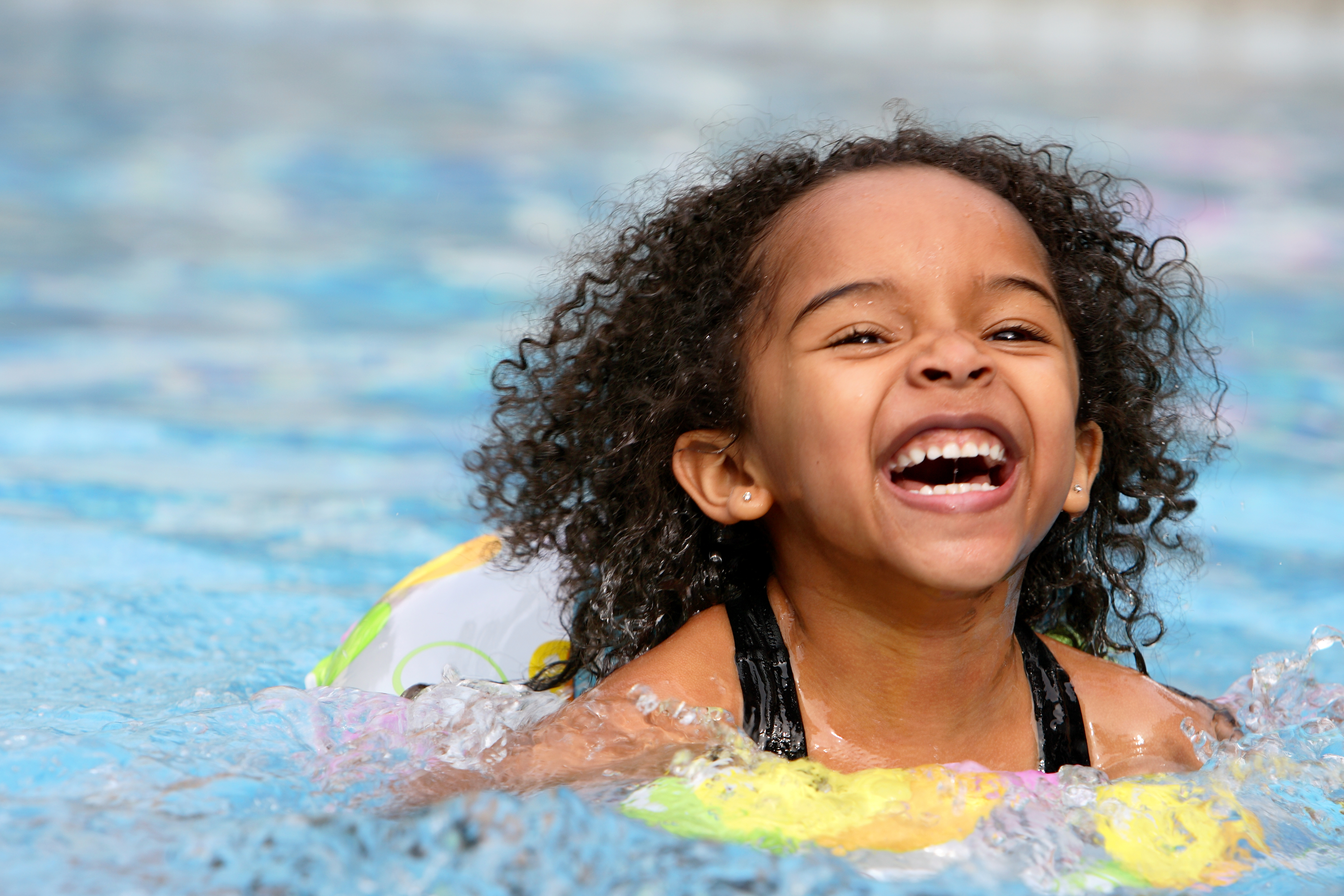 Little girl happily swimming.