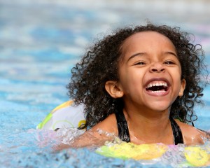 Little girl happily swimming.